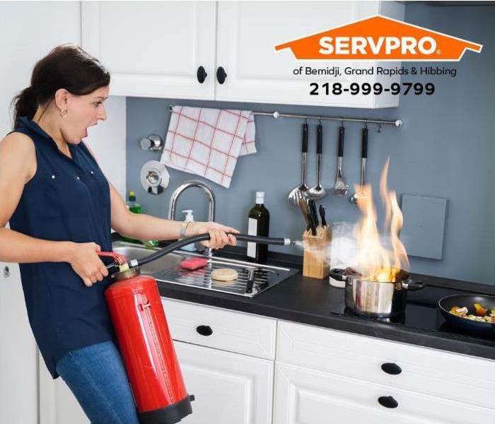 A person uses a fire extinguisher to out a kitchen fire.