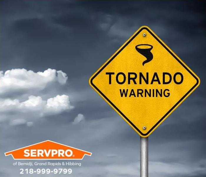A tornado warning sign is seen on a stormy day. 